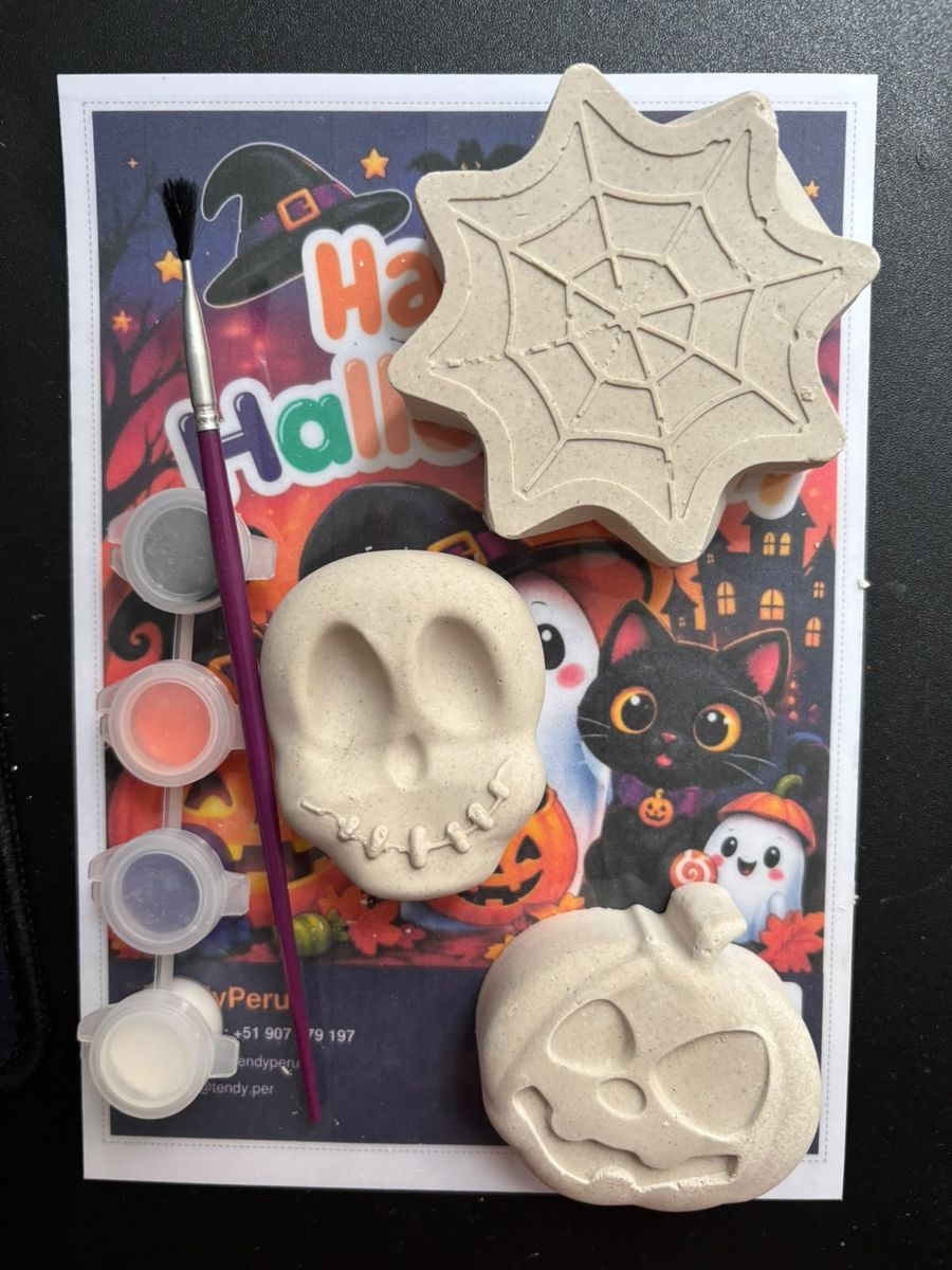 Kit de Halloween abierto: telaraña, calavera y calabaza de yeso sin pintar, cuatro potecitos de pintura, un pincel y la tarjeta ilustrada